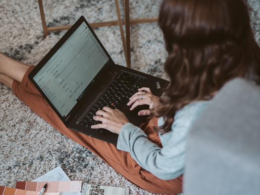 Woman working on a laptop on the floor